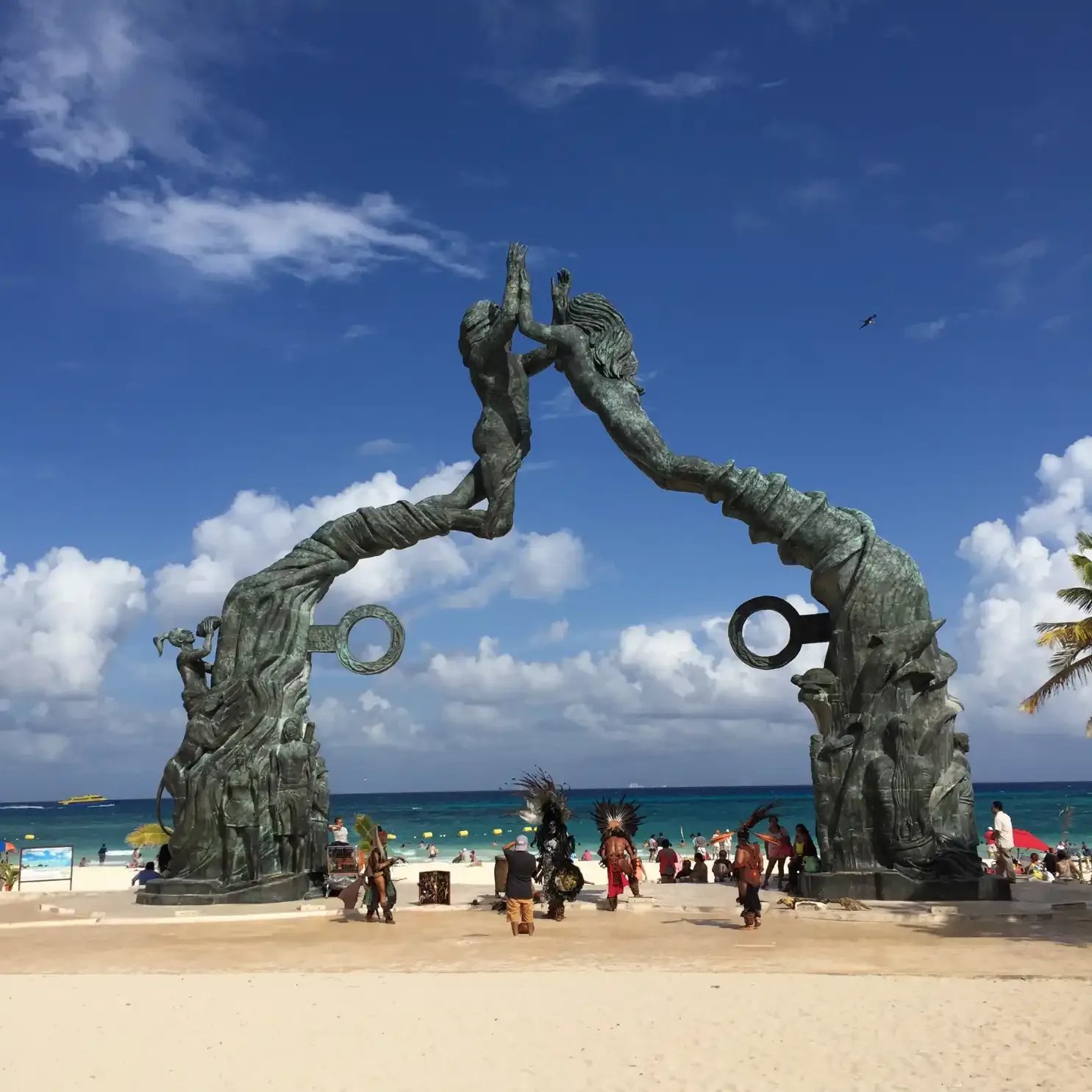 El Portal Maya de Playa del Carmen de día, con danzantes y el mar al fondo